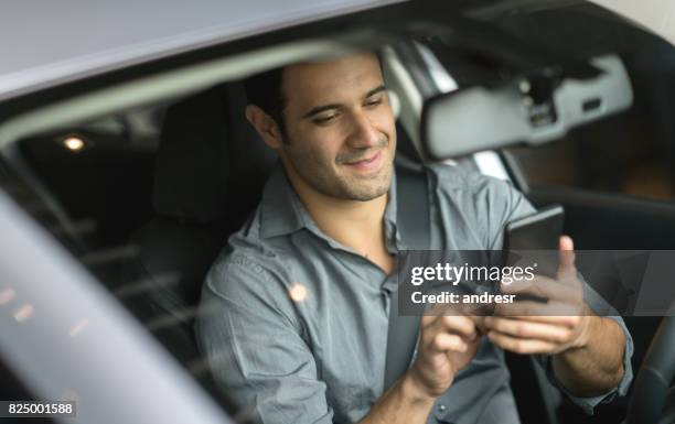 portrait of a man using his cell phone while driving - man atm smile stock pictures, royalty-free photos & images