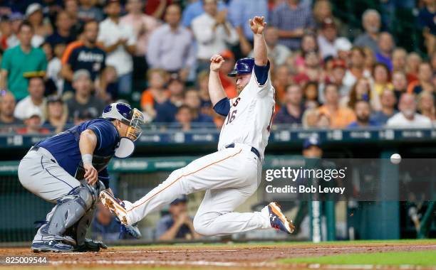 Brian McCann of the Houston Astros scores in the third inning as Wilson Ramos of the Tampa Bay Rays is unable to make the tag at Minute Maid Park on...