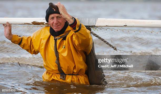 One of a group of Haaf netters fishes with nets on the mudflats of Port Carlisle in the Solway Firth estuary on August 21, 2008 near Wigton in...