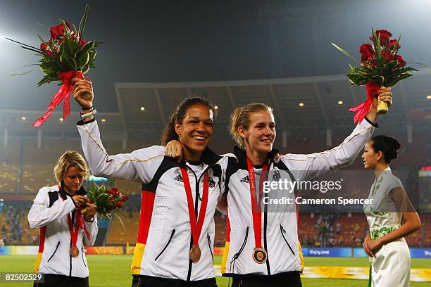 Celia Okoyino Da Mbabi and Simone Laudehr of Germany ceebrate after receiving their Bronze medals for the Women's Football on Day 13 of the Beijing...