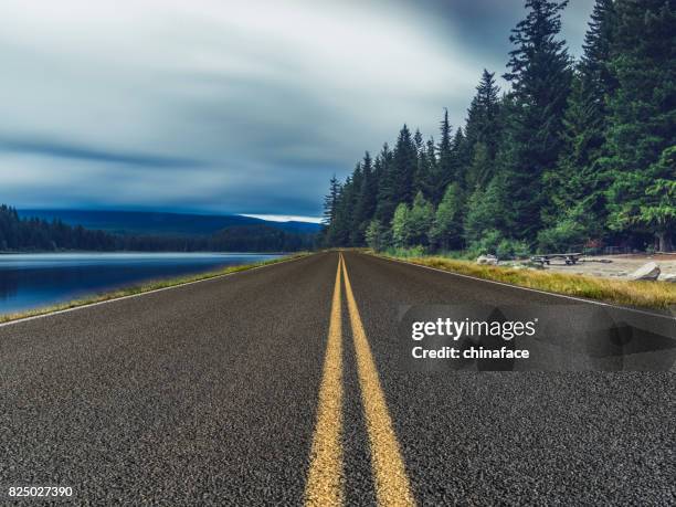 empty road travel through mount rainier national park in the morning,washington - washington state road stock pictures, royalty-free photos & images