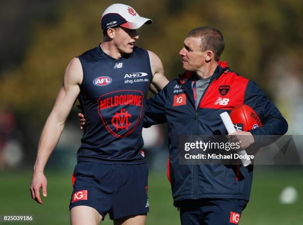 Sam Frost of the Demons is hugged as he talks with Demons head coach Simon Goodwin during a Melbourne Demons AFL training session at Gosch's Paddock...