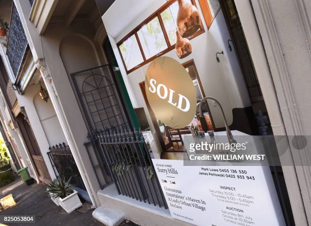 Sold sign on a real estate board advertising residential property is seen in front of a house in Sydney on August 1, 2017. - Australia's central bank...