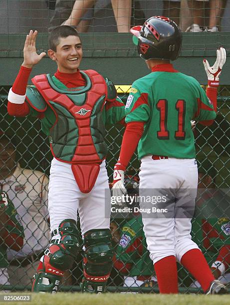 Catcher Fernando Villegas of Mexico congratulates Octavio Salinas after he scored in the fourth inning against Latin America during the international...