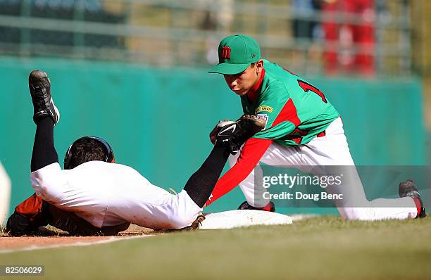 Pedro Florinson of Latin America just gets back to the base ahead of a tag by third baseman Emmanuel Rodriguez of Mexico during the international...