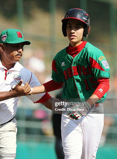 Coach Juan Carlos Rodriguez congratulates Sergio Rodriguez of Mexico after Rodriguez' solo home run in the first inning against Latin America during...