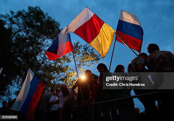 People fly Russian and Ossetian flags before a concert to commemorate South Ossetia's war dead August 21, 2008 in Tskhinvali, the capital of the...