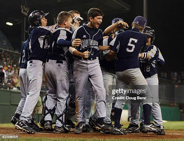Bryce Jordan of the Southwest is mobbed by teammates as they celebrate his home run while taking on the Southeast during the United States semi-final...