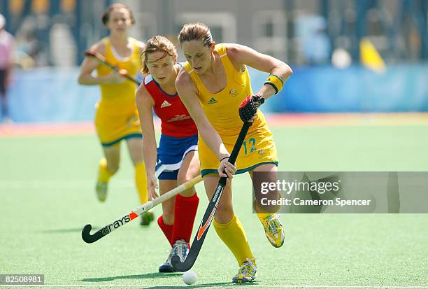 Madonna Blyth of Australia is chased by Sarah Thomas of Great Britain during the women's classification hockey match at the Olympic Green Hockey...
