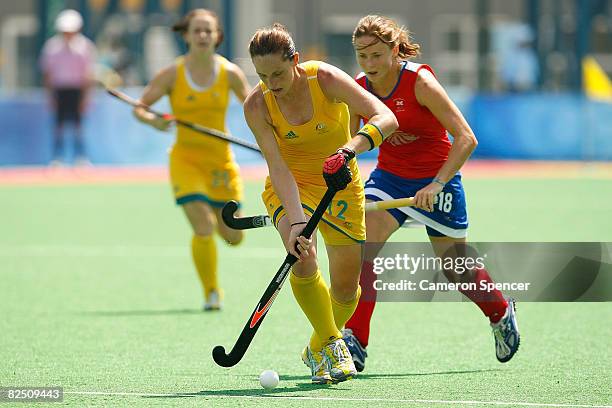 Madonna Blyth of Australia is chased by Sarah Thomas of Great Britain during the women's classification hockey match at the Olympic Green Hockey...