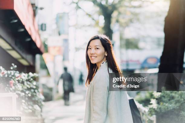 beautiful asian woman looking back with smile on the street - 女性　日本 ストックフォトと画像