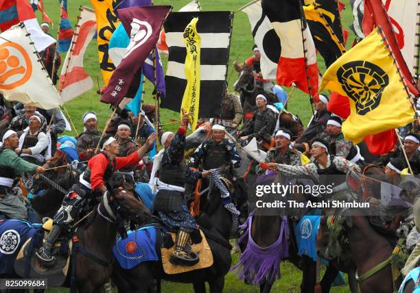 Horseback riders in full-body armor compete in the 'Shinki Sodatsusen', pursuit of the Goshinki 'sacred flag' during the 'Soma Nomaoi Festival' on...