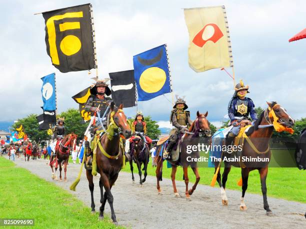 Horseback riders in full-body armor enter the field prior to the 'Soma Nomaoi Festival' on July 30, 2017 in Minamisoma, Fukushima, Japan.