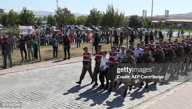 Defendants Kemal Batmaz and Akin Ozturk and other defendants are accompanied by gendarmerie as they arrive for their trial at Sincan Penal...