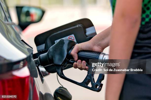 close-up of a hand pouring fuel into a car - gasoline pouring stock pictures, royalty-free photos & images