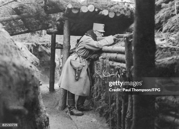 An Austrian soldier aims through a loophole in one of the outpost Carpathian trenches during World War I, circa 1915.