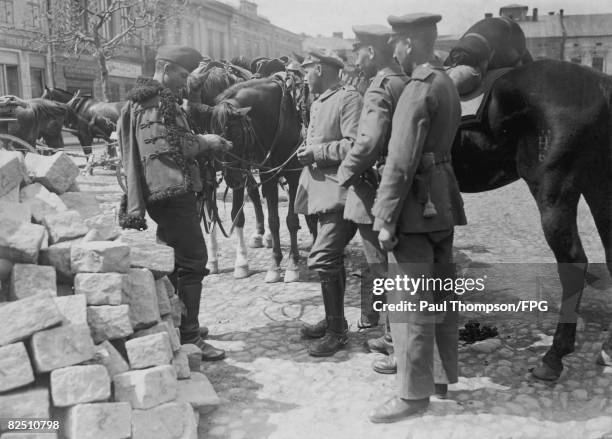 An Austrian hussar fraternises with German infantrymen at New Sandor during World War I, circa 1915.