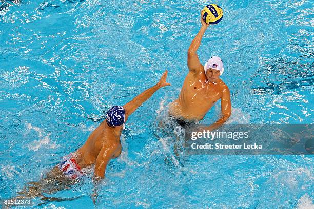 Jesse Smith of the United States looks for an open pass over Dejan Savic of Serbia in the men's semifinal water polo match at the Yingdong Natatorium...