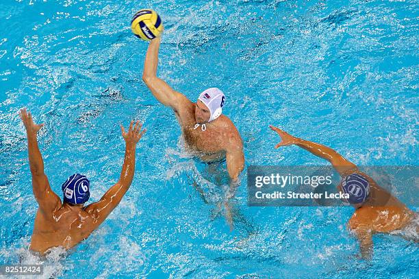 Rick Merlo of the United States looks to pass over Dusko Pijetlovic and Vladimir Vujasinovic of Serbia in the men's semifinal water polo match at the...