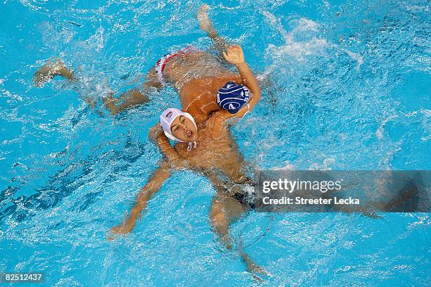 James Krumpholz of the United States is guarded of Vanja Udovicic of Serbia in the men's semifinal water polo match at the Yingdong Natatorium on Day...