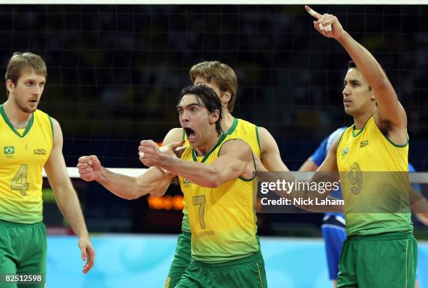 Gilberto Godoy Filho of Brazil reacts alongside teammates Andre Heller and Andre Nascimento of Brazil while taking on Italy during the semifinal...
