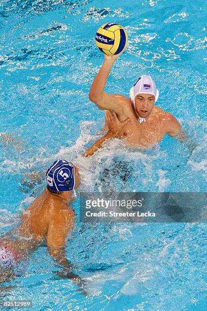 Tim Hutten of the United States looks for an open pass over Dejan Savic of Serbia in the men's semifinal water polo match at the Yingdong Natatorium...
