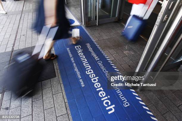 Passengers walk by a security sign warning for a Face recognition area at the Suedkreuz train station on August 1, 2017 in Berlin, Germany. German...