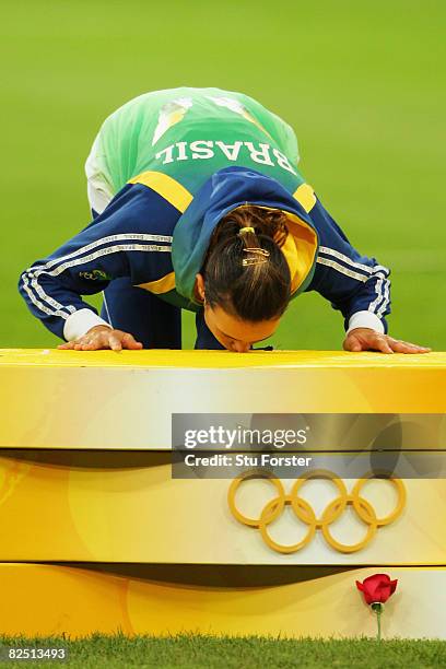Gold medalist Maurren Higa Maggi of Brazil kisses the podium during the medal ceremony for the Women's Long Jump Final at the National Stadium on Day...