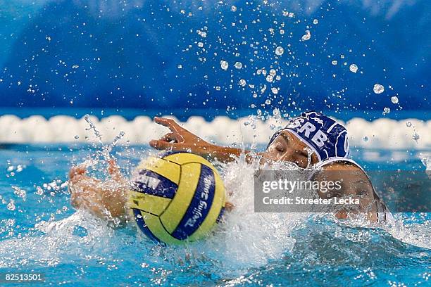 Tony Azevedo of the United States and Aleksander Ciric of Serbia battle for the ball in the men's semifinal water polo match at the Yingdong...