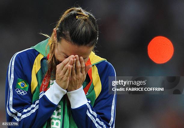 Brazil's Maurren Higa Maggi cries on the podium during the women's long jump medal ceremony at the "Bird's Nest" National Stadium during the 2008...