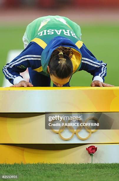 Brazil's Maurren Higa Maggi kisses the podium during the women's long jump medal ceremony at the "Bird's Nest" National Stadium during the 2008...