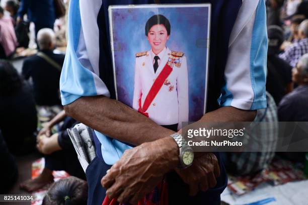 Supporter of ousted former Thai Prime Minister Yingluck Shinawatra holds a picture of Yingluck Shinawatra at the Supreme Court in Bangkok, Thailand...