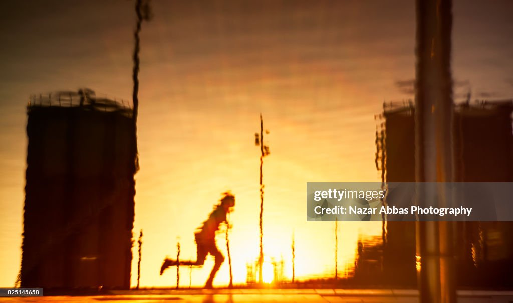 Reflection of a skateboarder with sunset in background.
