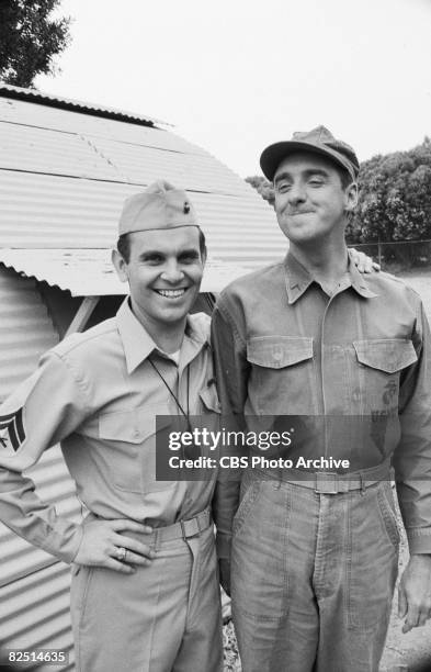 American actors Ronnie Schell and Jim Nabors stand outside a Quonset hut during the filming of an episode of the television comedy series 'Gomer...