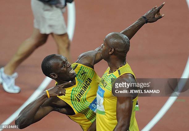 Jamaica's Usain Bolt celebrates next to teammate Asafa Powell after they won the men's 4?100m Relay final at the National Stadium during the 2008...