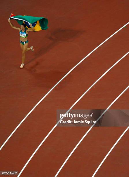Gold medalist Maurren Higa Maggi of Brazil runs a lap of victory with her gold medal following the medal ceremony for the Women's Long Jump Final at...