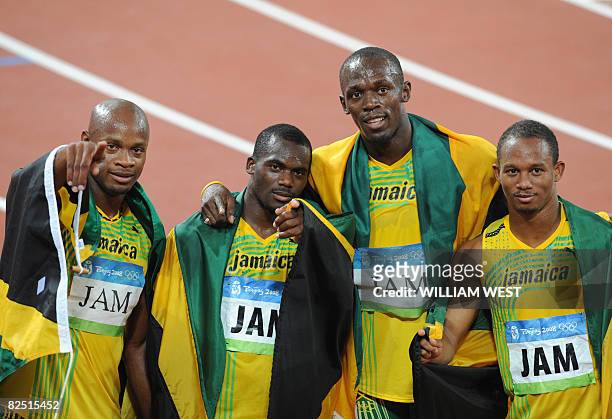 Jamaica's Asafa Powell, Nesta Carter, Usain Bolt and Michael Frater celebrate after winning the men's 4?100m Relay final at the National Stadium...