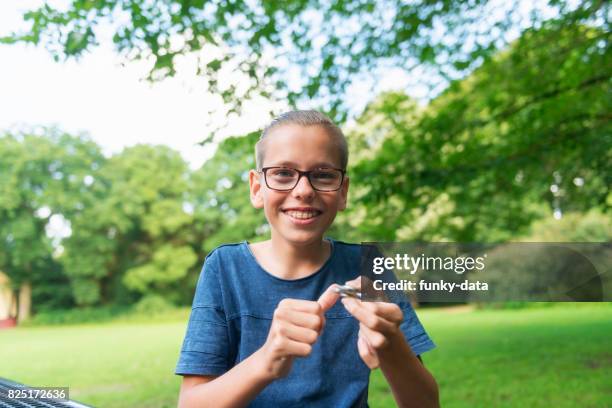 teenager using fidget spinner - androgynous boys stock pictures, royalty-free photos & images