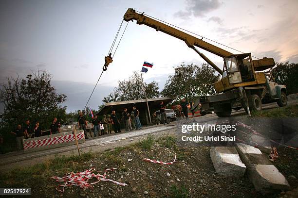 Russian peace keeping troops remove a concrete barrier as they pull out from the last checkpoint they control, near Kharvaleti, on the road from...