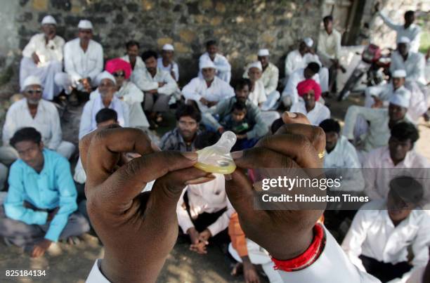 Young volunteers at village in Ausa block of Latur district demonstrate use of condoms to village folk, as a part of life skills training session on...