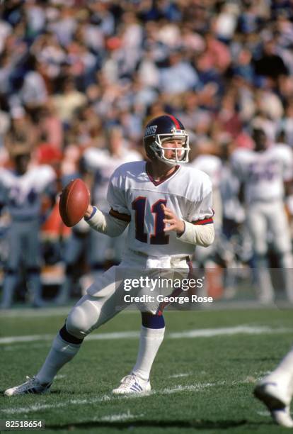 Quarterback Phil Simms of the New York Giants drops back to pass during the 1984 NFC Wild Card game against the Los Angeles Rams at Anaheim Stadium...