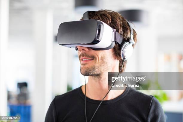 imprenditore che testa le cuffie del simulatore di realtà virtuale - solo un uomo foto e immagini stock