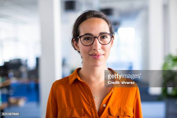 jonge zakenvrouw met brillen in kantoor - portretfoto stockfoto's en -beelden