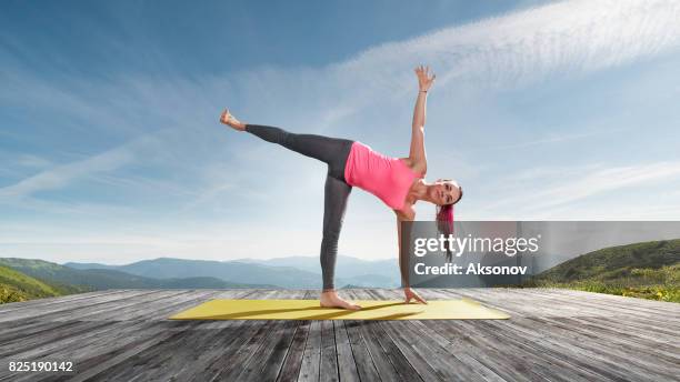 young beautiful woman practicing outdoors yoga - floating platform stock pictures, royalty-free photos & images