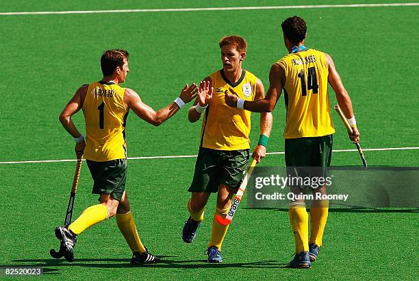 Ian Symons of South Africa celebrates a goal with his teammates Andrew Cronje and Eric Rose-Innes in the Men's Classification 11-12 match between...