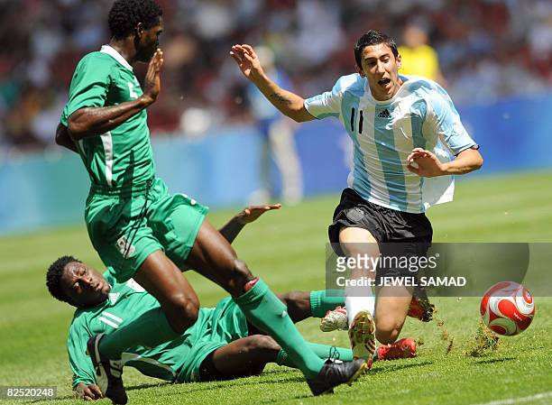 Argentinian midfielder Angel Di Maria is tackled by Nigerian forward Solomon Okoronkwo next to Nigerian defender Dele Adeleye during the men's...