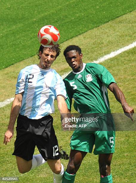 Argentinian defender Nicolas Pareja and Nigerian defender Dele Adeleye jump for the ball during the men's Olympic football final Argentina vs....