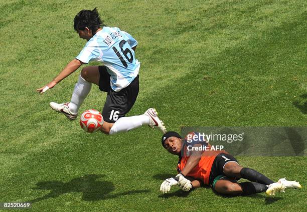 Argentinian forward Sergio Aguero jumps with the ball over Nigerian goalkeeper Ambruse Vanzekin during the men's Olympic football final Argentina vs....