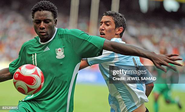 Nigerian forward Solomon Okoronkwo vie for the ball with Argentinian midfielder Angel Di Maria during the men's Olympic football final Argentina vs....