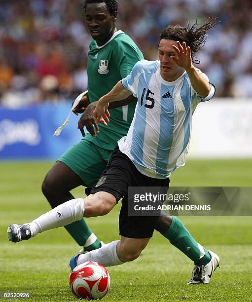 Nigerian defender Dele Adeleye challenges Argentinian forward Lionel Messi during the men's Olympic football final Argentina vs. Nigeria at the...